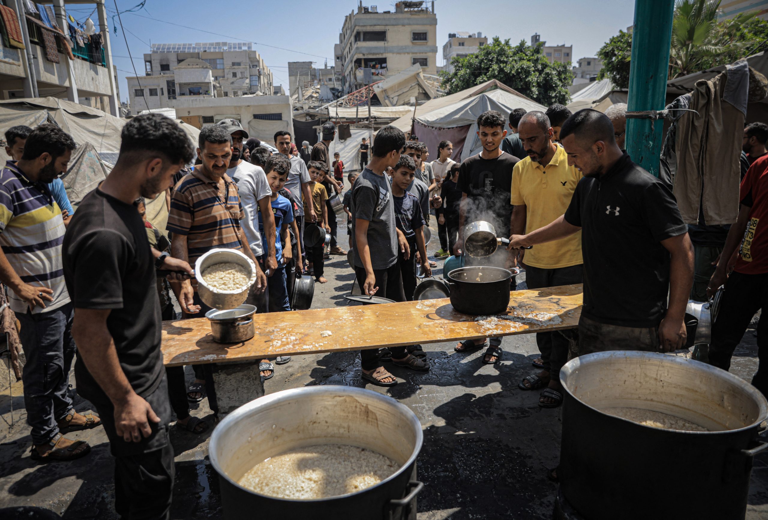 فلسطنيون ينتظرون دورهم للحصول على وجبات طعام (أ ف ب)