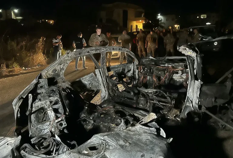 جنود من الجيش اللبناني يتفقدون حطام سيارة استُهدفت بهجوم شنته طائرة مسيّرة إسرائيلية في جنوب لبنان (AFP)