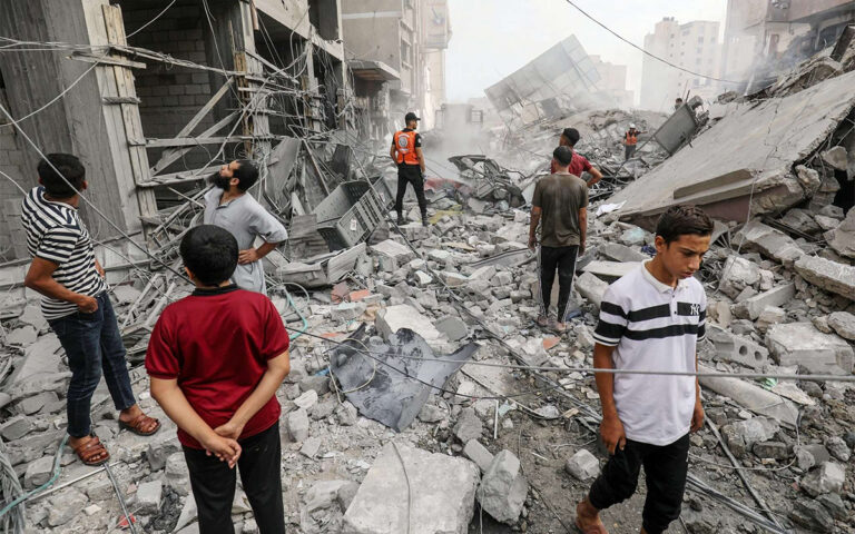 فلسطينيون من مدينة خان يونس يتفقدون مباني مدمرة نتيجة القصف الاسرائيلي