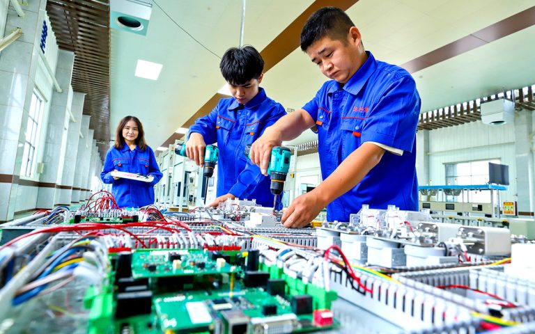 عمال صينيون في احد مصانع مركبات كهربائية (أ ف ب)