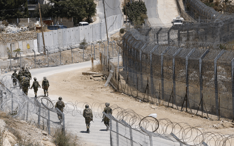 جنود إسرائيليون يمشون على الحدود مع سوريا بالقرب من بلدة مجدل شمس (أ ف ب)