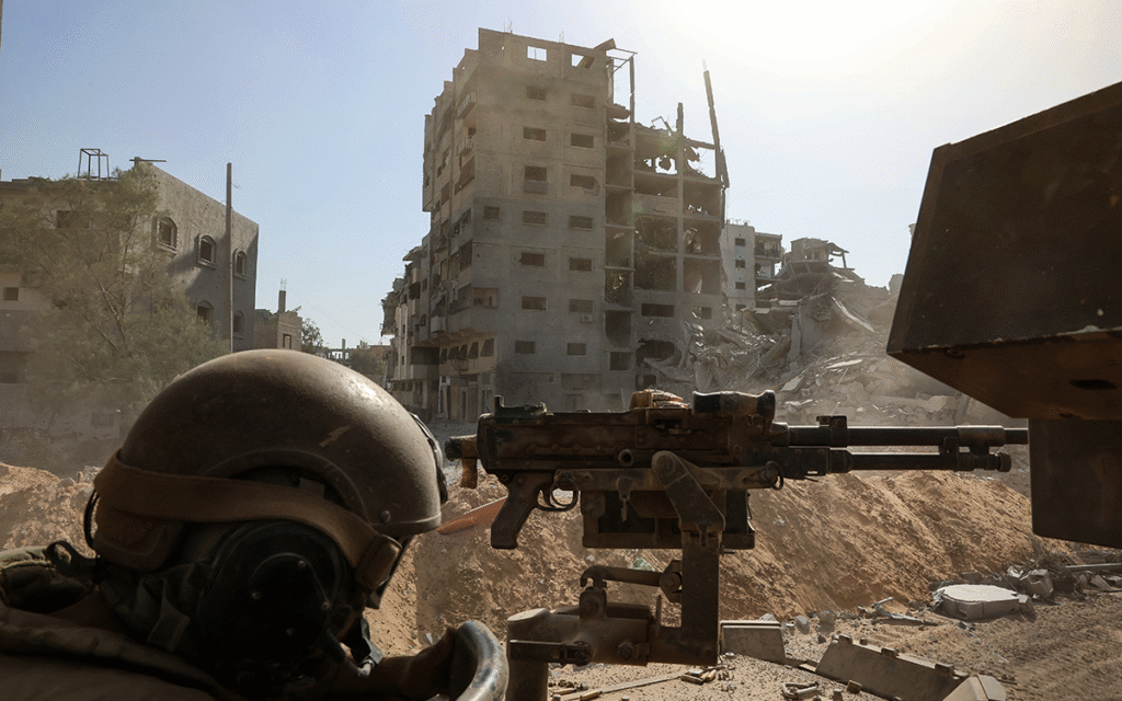 جندي إسرائيلي خلف مدفع رشاش في محيط المستشفى الميداني الأردني في غزة (أ ف ب)