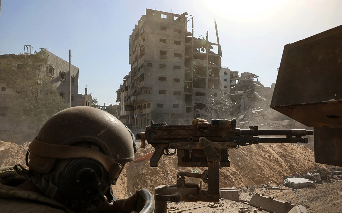 جندي إسرائيلي خلف مدفع رشاش في محيط المستشفى الميداني الأردني في غزة (أ ف ب)