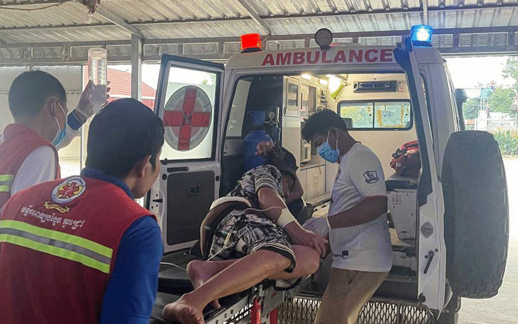عمال الصحة الكمبوديون ينقلون رجلاً مصاباً إلى سيارة إسعاف (أ ف ب)