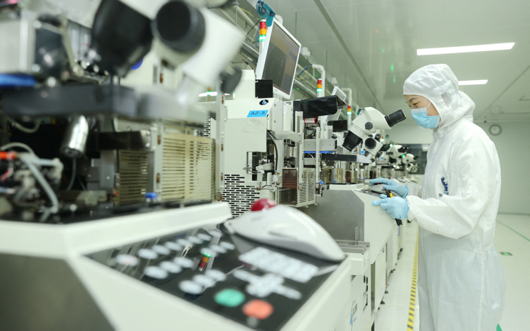 موظفة تعمل على خط إنتاج أشباه الموصلات (أ ف ب)