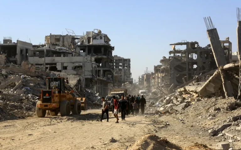 فلسطينيون يسيرون وسط الركام في غزة