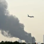 دخان يتصاعد من محيط مطار دبي بعد إسقاط مسيرة إيرانية (أ ف ب)