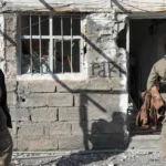 يتفقد أحد أعضاء قوات البيشمركة الكردية الإيرانية التابعة للحزب الديمقراطي الكردستاني الإيراني الأضرار التي لحقت بمعسكر آزادي (أ ف ب)