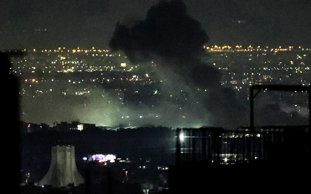 تصاعد أعمدة الدخان عقب غارات جوية في غرب طهران (أ ف ب)