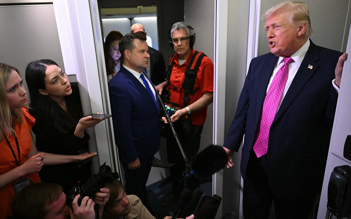 ترامب متحدثا للصحفين على متن الطائرة الرئاسية (أ ف ب)