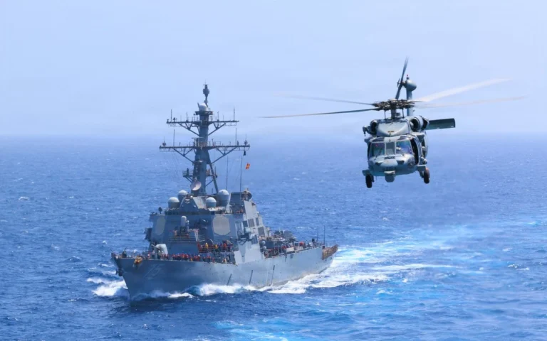 المدمرة الأمريكية يو إس إس دونالد كوك ومروحية MH-60S سي هوك خلال فرض الحصار البحري على إيران في بحر العرب.