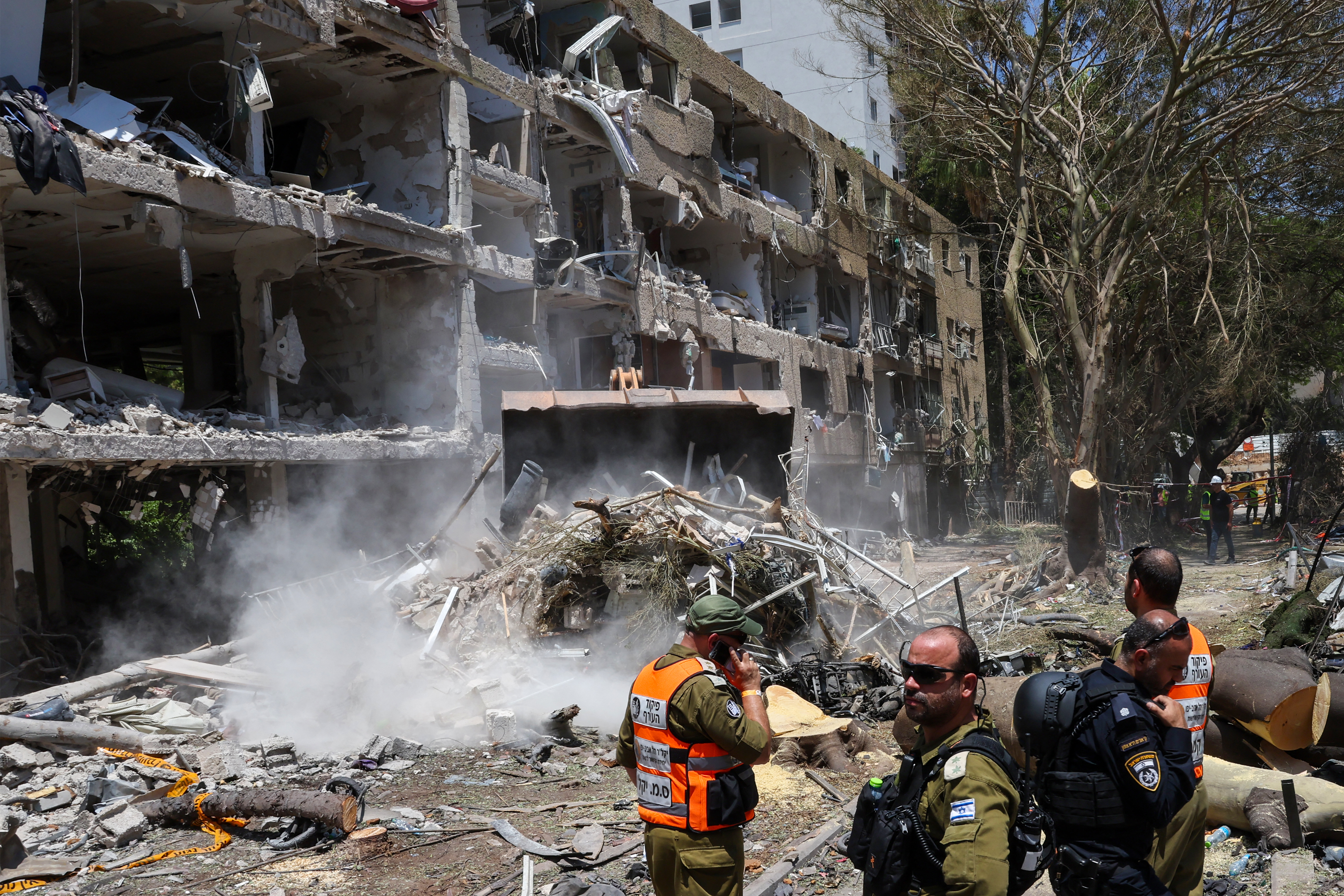 A digger clears rubble in Tel Aviv after an Iranian strike in response to U.S. bombing. AFP