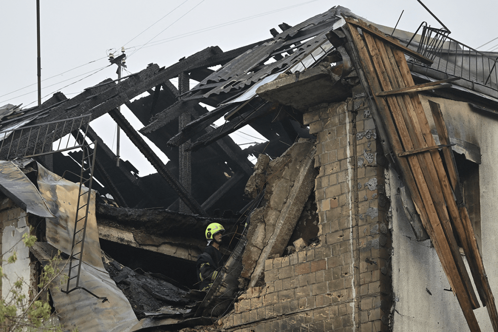A Ukrainian firefighter in a damaged residential building after a Russian drone attack. AFP