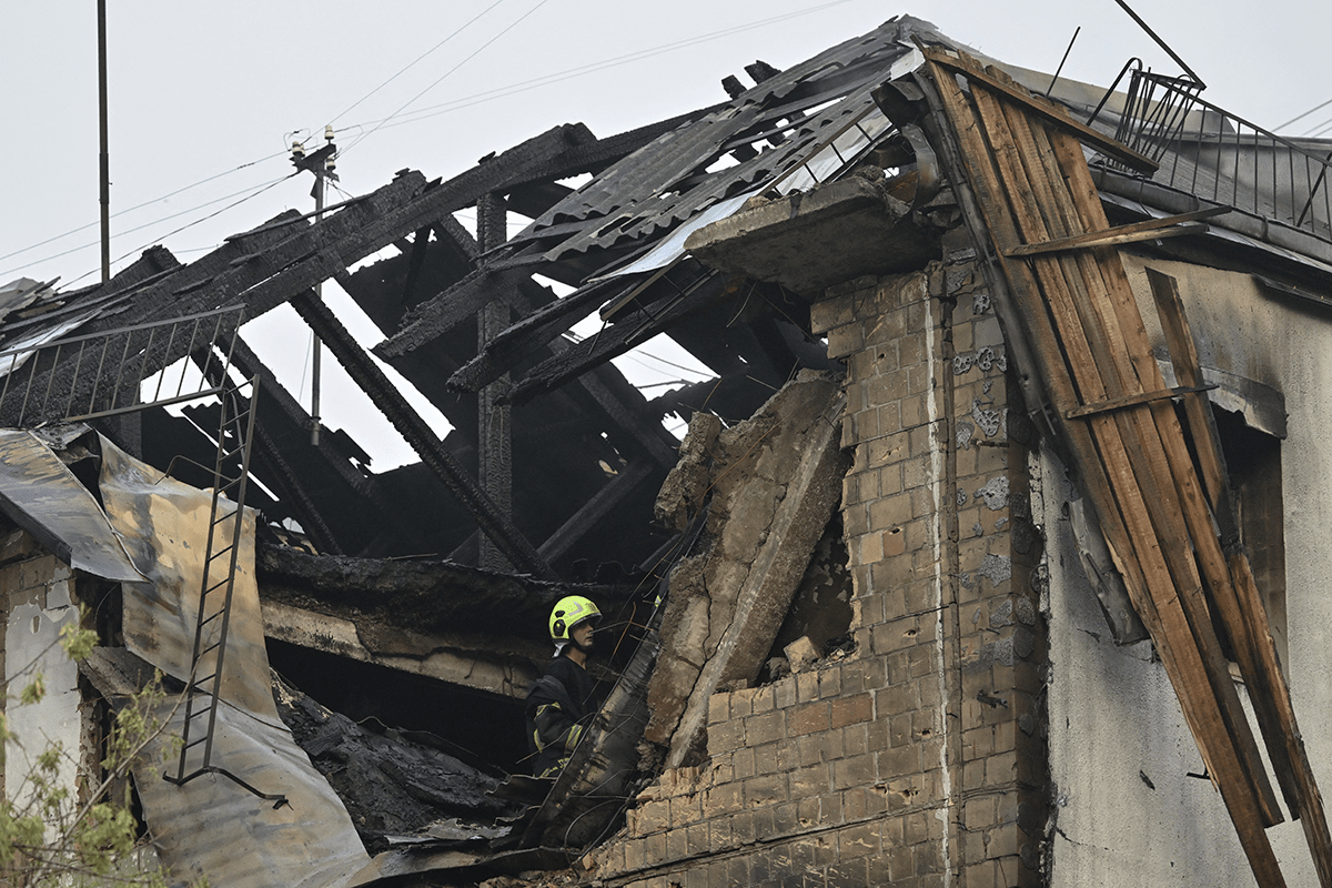 A Ukrainian firefighter in a damaged residential building after a Russian drone attack. AFP