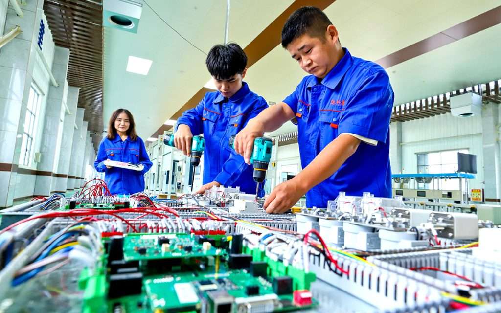 Chinese workers in an electric vehicle factory. AFP