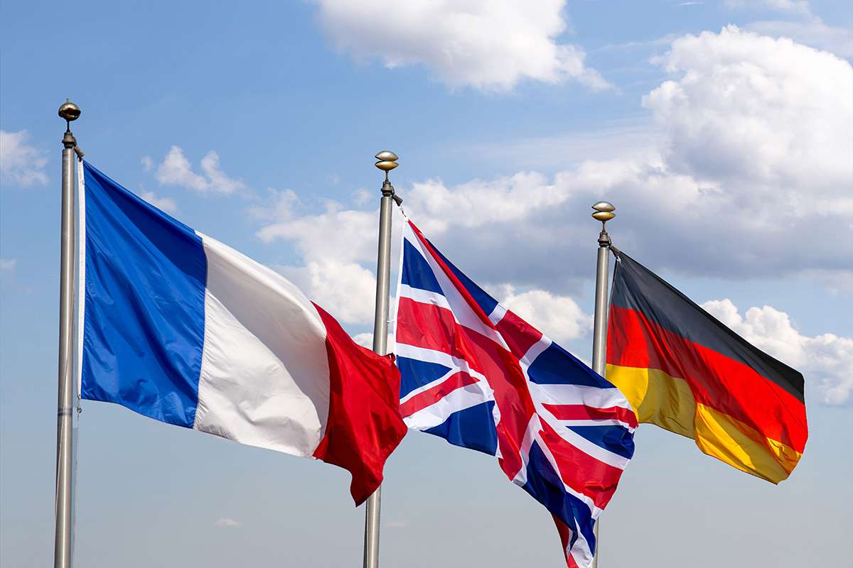 Flags of France, Great Britain and Germany against a blue sky