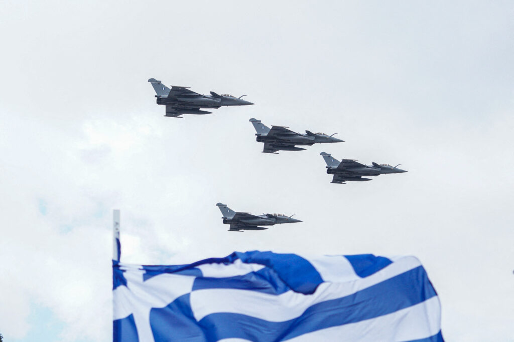 Rafale-type aircraft fly in the sky behind a Greek flag during the military parade for Greek Independence Day in Athens, Greece