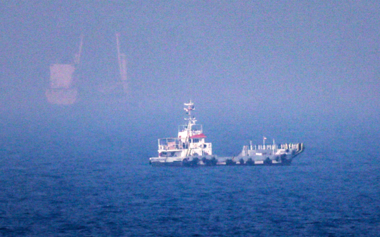 A white ship can be seen in the waters of the Strait of Hormuz