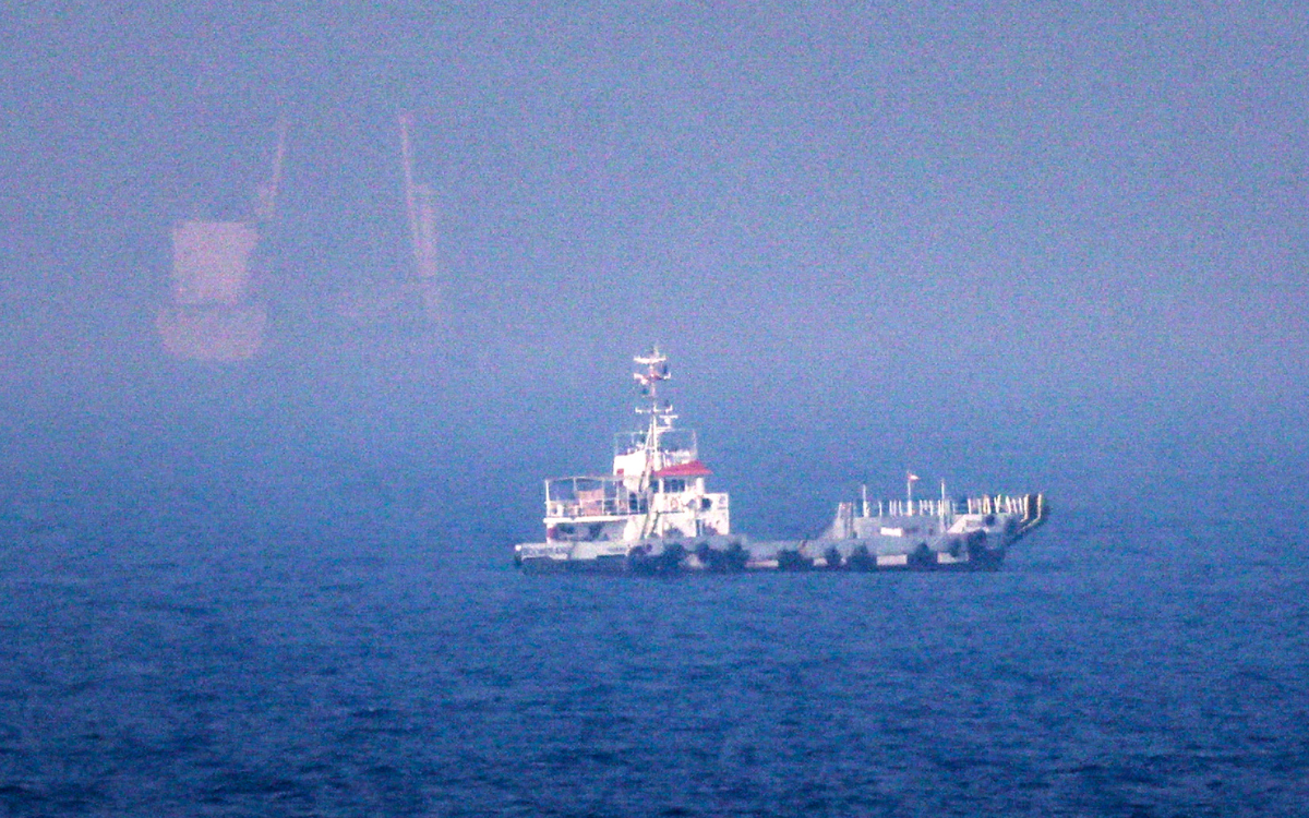 A white ship can be seen in the waters of the Strait of Hormuz