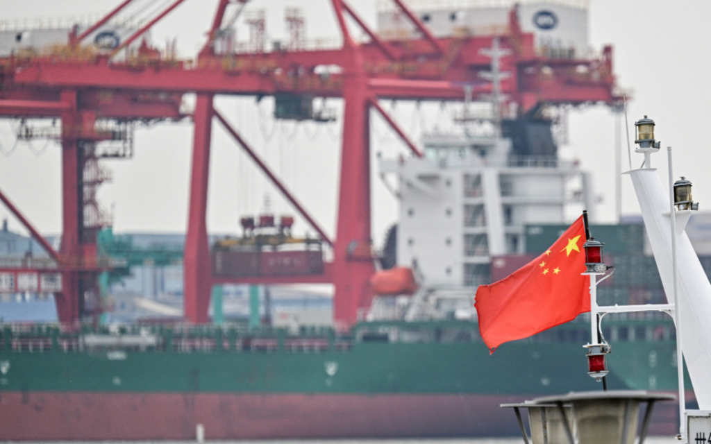 A Chinese flag is pictured on a boat in front of a cargo ship