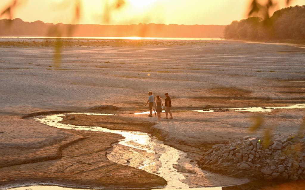 People walk across sandbars exposed by the low water level of the Danube River in Serbia.