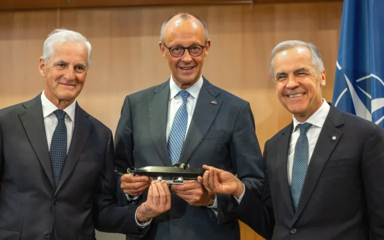Merz, Carney and Jonas Gahr Store hold a model TKMS submarine for CPSP in Ankara