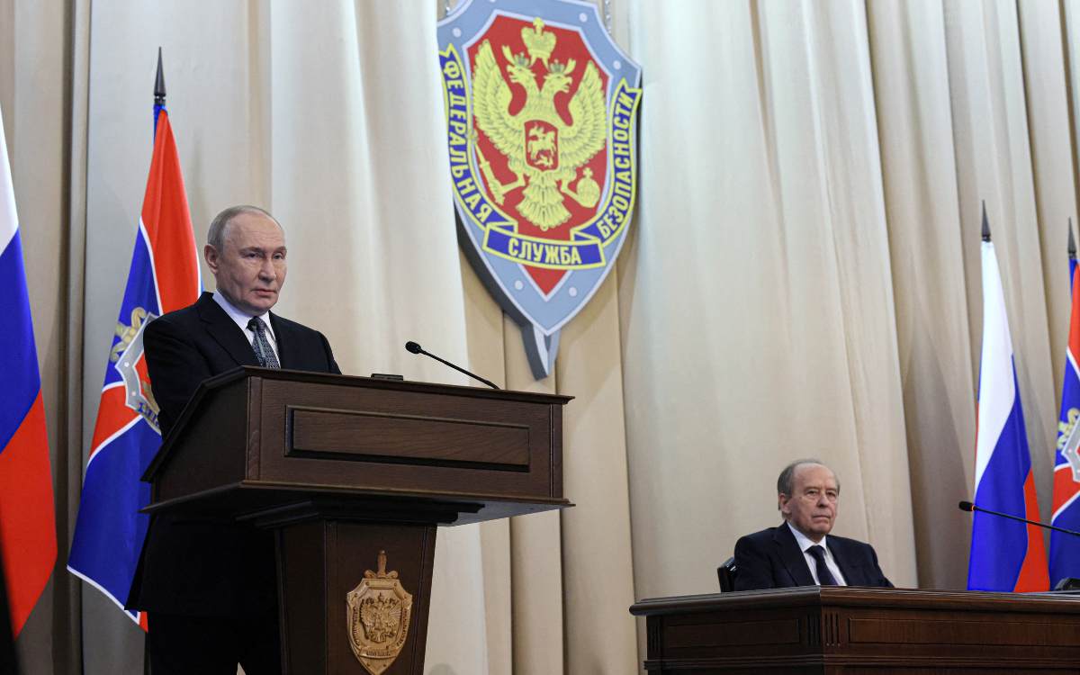 In this pool photograph distributed by the Russian state agency Sputnik, Russia's Federal Security Service Director Alexander Bortnikov (R) listens to Russia's President Vladimir Putin (L) as he gives a speech during a meeting of the Federal Security Service Board in Moscow on February 24, 2026. 